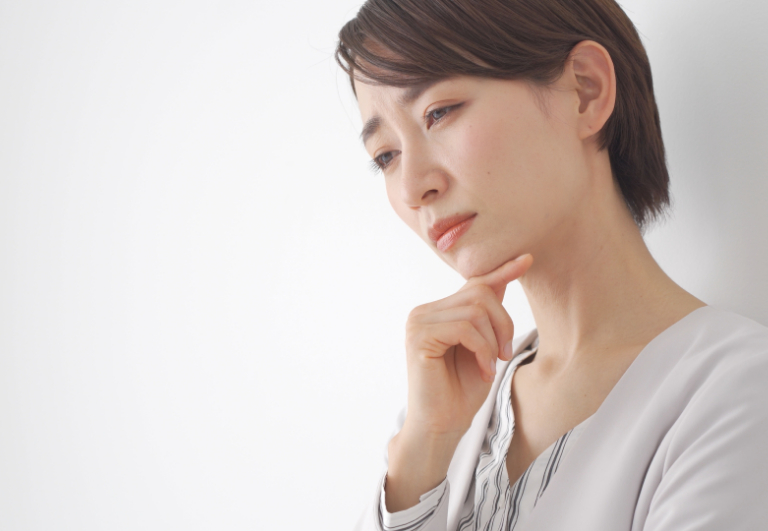 あごに手をあて考え事をする女性